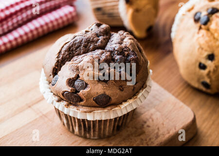 Muffins au chocolat et à la vanille sur la surface en bois. dessert concept. Banque D'Images