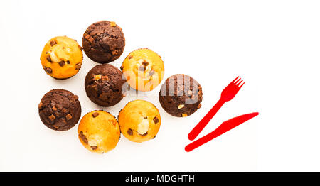 Une sélection de muffins et couteau rouge et jaune folk sur surface de travail, tourné de haut en bas Banque D'Images