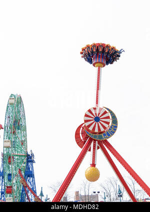 Situé à Luna Park de Coney Island à Brooklyn New York sous couvert ciel blanc brillant, à sensations fortes en mouvement avec les jambes pendantes. Banque D'Images