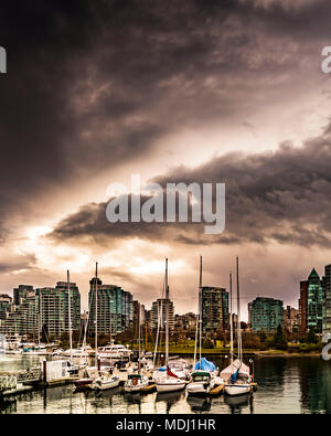 Immeubles en copropriété et voiliers amarrés dans le port sous de sombres nuages ; Vancouver, Colombie-Britannique, Canada Banque D'Images