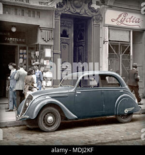 Garé dans une rue de France 1948, cette Peugeot 202 Berline. Le corps en acier 202 a été immédiatement reconnu comme une Peugeot à partir de la façon dont les phares étaient fixés derrière la calandre. Cette berline quatre portes (berline) version est venu avec un panneau en acier, toit ouvrant coulissant. En 1948, les roues ont été embellis avec enjoliveurs chromés. Libre à partir de l'original colorisée de l'appareil B&W négatif. Banque D'Images