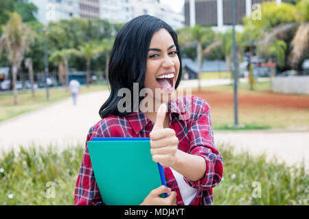 Les succès d'Amérique latine femme thumboutdoors montrant des étudiants sur le campus de l'université Banque D'Images