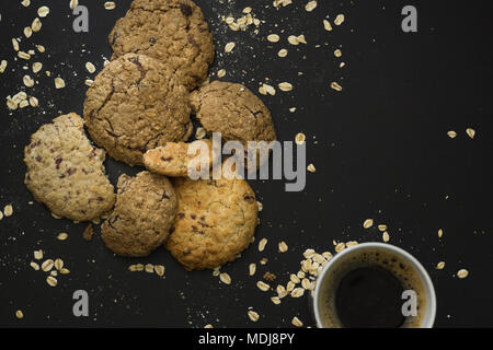 Cookies avoine et du café sur fond noir. Banque D'Images