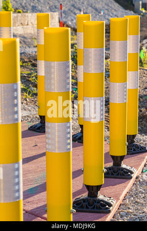 Passage à niveau plusieurs tubes de sécurité jaune reflétant le lever du soleil Banque D'Images