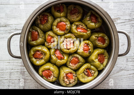 Biber Dolmasi Poivrons farcis / turc dans une casserole sur une surface en bois blanc. Banque D'Images