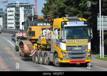 Un groupe de Searle Volvo FH16 unité tracteur tractant une remorque-engin Nooteboom portant un W M Plant Hire Caterpillar CAT 345C excavatrice longue portée Banque D'Images