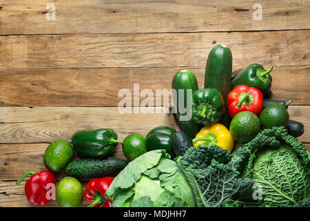 Divers produits frais bio Légumes verts Chou Concombre Courgette Poivrons jaunes rouges Avocats sur planche en bois patiné Grange Arrière-plan. Supe Banque D'Images