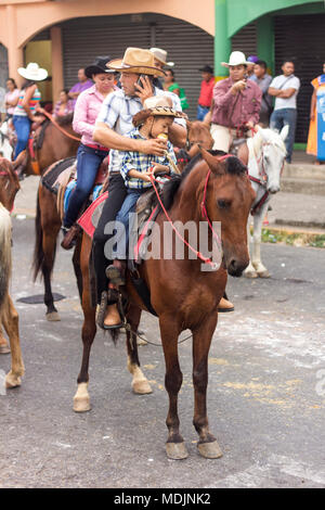 Un père et son fils, faire du cheval dans les rues de David, Panama, dans le rapport annuel de la Cabalgata, David festival équestre de David. Banque D'Images