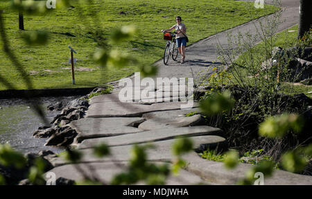 Bruxelles, Belgique. Apr 19, 2018. Une femme marche dans un parc de Bruxelles, Belgique, le 19 avril 2018. La température ici ont augmenté à environ 28 degrés Celsius, ce qui rend le jeudi 19 avril le plus chaud depuis que les relevés météorologiques. Credit : Ye Pingfan/Xinhua/Alamy Live News Banque D'Images