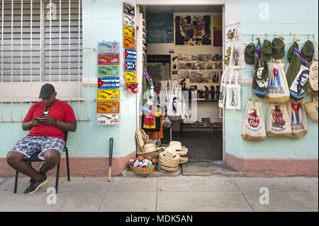 Cienfuegos, Cuba. 24 Nov, 2017. Un concessionnaire est assis en face de son magasin de souvenirs à Cienfuegos en attente de clients. (24 novembre 2017) | dans le monde entier : dpa Crédit/Alamy Live News Banque D'Images