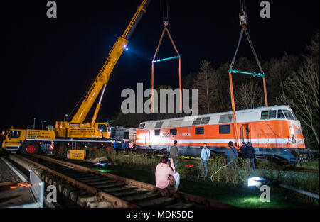 19 avril 2018, l'Allemagne, deux grues : Gadebusch soulever une tonne 78 locomotives au diesel du modèle V-180 dans le musée ferroviaire à l'extérieur de la gare locale. La soi-disant 'cigare' locomotive a été construit en 1967. Photo : Jens Büttner/dpa-Zentralbild/dpa Banque D'Images