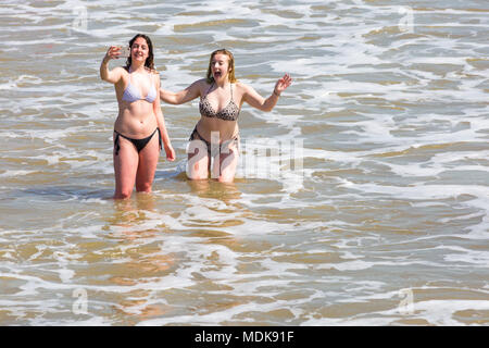 Bournemouth, Dorset, UK. 20 avril 2018. Météo France : les plages sont bondées de visiteurs affluent à la plage pour profiter du beau temps à Bournemouth. Deux jeunes femme s'amusant en tenant vos autoportraits dans la mer. Credit : Carolyn Jenkins/Alamy Live News Banque D'Images