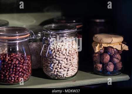 Les ustensiles de cuisine sur l'étagère. Les pots avec des haricots dans la cuisine garde-manger. Vieux intérieurs stylisés. Banque D'Images