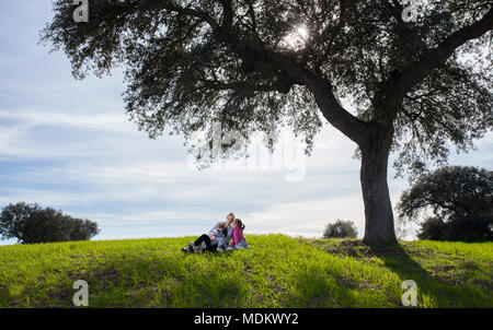 Mère avec la fille et le fils en vertu de l'arbre d'acorn dehesa. Profiter de la nature en famille concept Banque D'Images