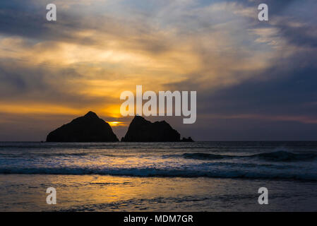 Un spectaculaire coucher de soleil sur l'emblématique charretiers des roches en Baie de Holywell à Cornwall. Banque D'Images