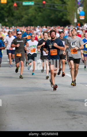 Atlanta, GA, USA - 4 juillet 2014 : Des milliers de coureurs descendre dans une rue d'Atlanta sur leur chemin vers la ligne d'arrivée du Peachtree Road Race. Banque D'Images