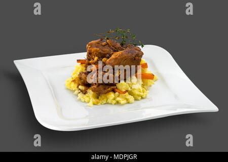 Morceaux de viande de porc rôtie garnie de purée de pommes de terre, les carottes et les herbes Banque D'Images