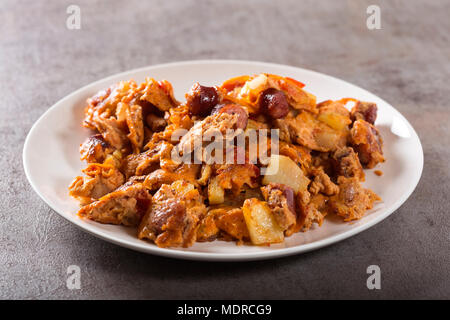 Partie d'omelette faite avec des oeufs, des pommes de terre, saucisses et sauce tomate Banque D'Images