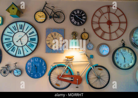 Une collection d'horloges et des bicyclettes de modèle décorer un mur. Banque D'Images