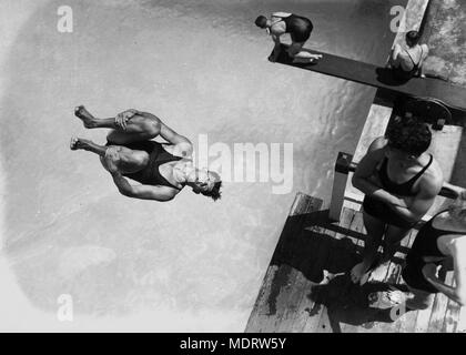 La plongée dans la vallée des Bains, Brisbane, Queensland, 1938. Emplacement : Fortitude Valley, Brisbane, Queensland, Australie ; -27.454132, 153,036729. Description : Une photo d'action d'un jeune homme de plongée une tour à la piscine de la vallée. D'autres jeunes hommes en costumes de natation sont en attente à son tour sur la tour et sur un plongeoir. Les bains sont dans Wickham Street, Fortitude Valley, et sont encore largement utilisés par la communauté Brisbane aujourd'hui. Banque D'Images