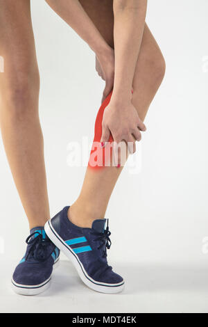 Une jeune femme est aux prises avec la douleur, isolé sur l'arrière-plan Banque D'Images