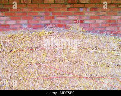 Mur de brique rouge avec des bottes de paille et foin copyspace Banque D'Images