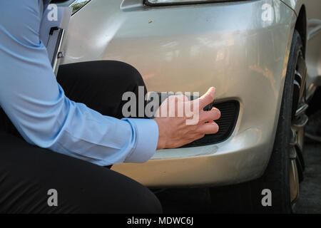 L'agent Young man holding smart phone pour prendre une photo de voiture ventilées par accident de la circulation pour demander l'assurance automobile. Banque D'Images