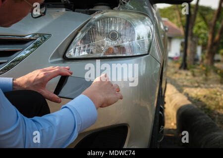 L'agent Young man holding smart phone pour prendre une photo de voiture ventilées par accident de la circulation pour demander l'assurance automobile. Banque D'Images