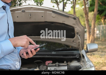 L'utilisation de l'agent masculin smart phone pour demander l'assurance automobile. caucasian man appeler à l'aide de voitures endommagées par accident de la circulation Banque D'Images