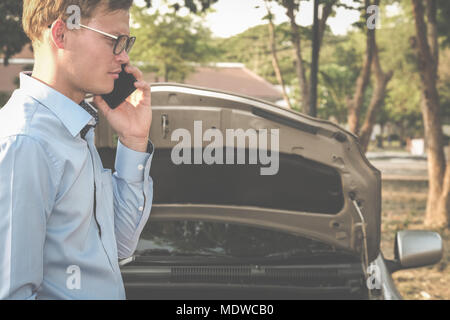 L'utilisation de l'agent masculin smart phone pour demander l'assurance automobile. caucasian man appeler à l'aide de voitures endommagées par accident de la circulation Banque D'Images