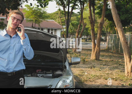 L'utilisation de l'agent masculin smart phone pour demander l'assurance automobile. caucasian man appeler à l'aide de voitures endommagées par accident de la circulation Banque D'Images