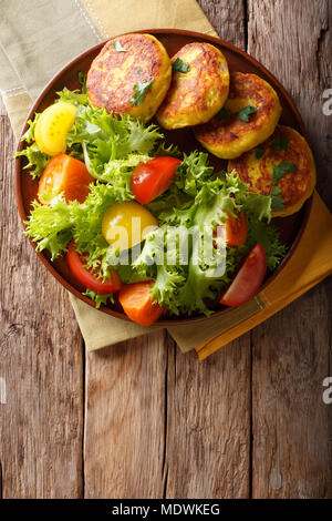 Les galettes de pommes de terre fraîchement préparés sont servis avec salade fraîche gros plan sur une assiette. Haut Vertical Vue de dessus Banque D'Images