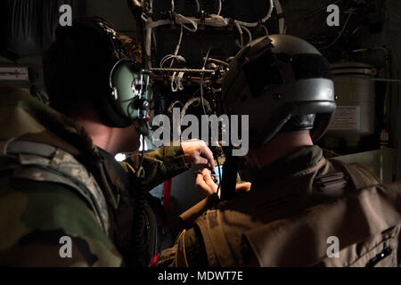 Havene Lieutenant Robert, 41e Escadron de transport de troupes C-130J Super Hercules pilot, élabore un problème pré-vol avec un aviateurs du 374e Escadron de maintenance au cours de l'exercice Vigilant Ace 18, le 6 décembre 2017, à Yokota Air Base, le Japon. L'exercice offre une formation essentielle pour les aviateurs pour maintenir la paix et la stabilité dans la région du Pacifique Indo-Asia. (U.S. Photo de l'Armée de l'air par la Haute Airman Donald Hudson) Banque D'Images