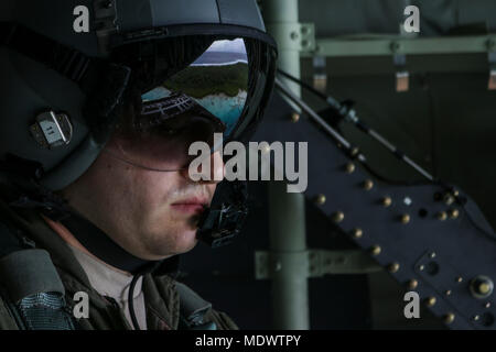 Navigant de première classe Stephen Clark, 36e Escadron de transport aérien l'arrimeur, donne sur l'arrière d'un C-130J Super Hercules avant de pousser un paquet à l'arrière de l'avion comme l'équipage passe au-dessus d'une île micronésienne opération lors de la 66e chute de Noël, le 11 décembre 2017. L'équipage largués de la nourriture, des fournitures et du matériel éducatif pour les insulaires à travers le Commonwealth des îles Mariannes du Nord, les États fédérés de Micronésie, et la République de Palau. Ces îles sont parmi les plus éloignées du globe sur une distance presque aussi large que la partie continentale des États-Unis. (U.S. Air Force p Banque D'Images