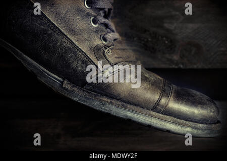 Détail de cuir gris chaussures occasionnels pour l'homme sur planche de bois. L'humeur sombre de style. Image horizontale. Banque D'Images