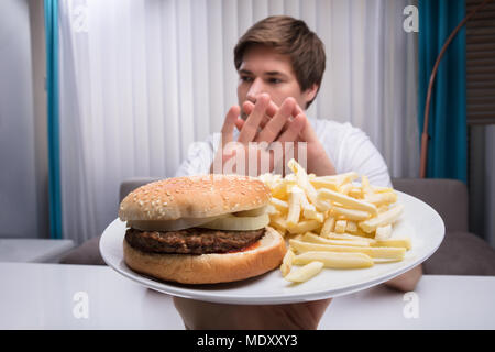 L'homme refusant d'aliments malsains offerte par une personne Banque D'Images