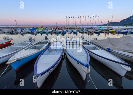 Harbour marina avec des rangées de bateaux de pêche amarré sur le lac de Garde (Lago di Garda) à l'aube à Garda en Vénétie, Italie Banque D'Images