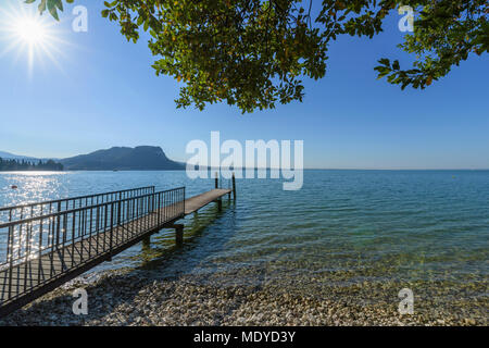 Soleil sur le lac de Garde (Lago di Gardo) avec sol en bois jetée dans l'été à Garda en Vénétie, Italie Banque D'Images