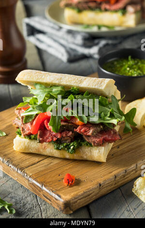 Pavé de boeuf maison Sandwich avec roquette et Chimichurri Banque D'Images