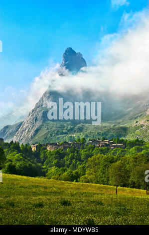 Le village de Chiappera, dans la haute vallée de la Maira à Piedmont, le rock, surmontée d 538, partiellement enrobée depuis les nuages. Banque D'Images