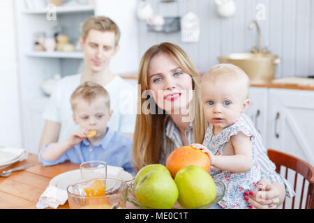 Si mignon famille. Jeune mère et père avec sa petite fille et son fils. Cuisine moderne. Funny Girl avec maman sur la cuisine Banque D'Images