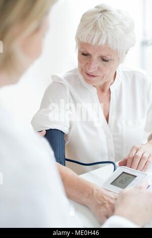 Senior woman having blood pressure taken. Banque D'Images