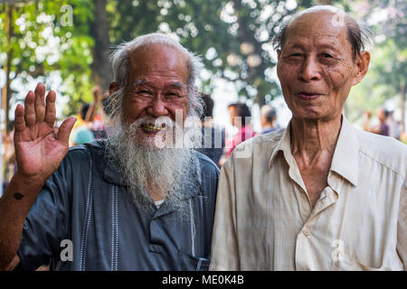 Poser des hommes âgés en souriant et en agitant pour l'appareil photo ; Hanoi, Hanoi, Vietnam Banque D'Images