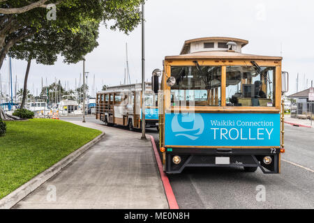 Chariots Waikiki attendent des passagers sur la rue Holomoana près du port de plaisance d'Ala Wai (en arrière-plan) à Waikiki Banque D'Images