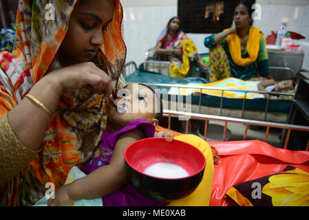 Une mère bangladais Saline nourrir ses enfants qui souffre de diarrhée sont au centre international pour la recherche sur les maladies diarrhéiques, Banglad Banque D'Images