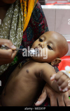 Une mère bangladais Saline nourrir ses enfants qui souffre de diarrhée sont au centre international pour la recherche sur les maladies diarrhéiques, Banglad Banque D'Images