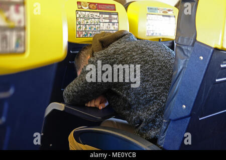 Un homme endormi sur un vol Ryanair Banque D'Images