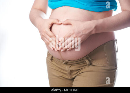 Les soins de maternité en bonne santé thème. Le ventre de la femme enceinte avec des mains en forme de coeur sur le dessus Banque D'Images