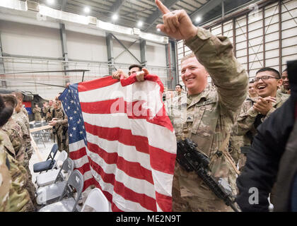 Soldats tenir le drapeau américain lors de l'USO Tour de l'aérodrome de Bagram, le 24 décembre 2017. Dunford et Troxell, ainsi que des artistes de l'USO, visité les membres de service qui sont déployés pendant les vacances. Cette année, le spectacle sont Chef Robert Irvine, catcheur Gail Kim, comédien Iliza Shlesinger, acteur Adam Devine, musicien country Jerrod Niemann, WWE Superstars et le "Im" et Alicia Fox. (DoD photo par Marine Maître de 1ère classe Dominique A. Pineiro/libérés) Banque D'Images