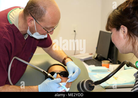 Le lieutenant-colonel Gregory Schmidt, un dentiste affecté à la 122e Escadre de chasse de la Garde nationale aérienne de l'Indiana, effectue un nettoyage des dents sur un jeune patient comme sa mère ressemble à l'appui des soins de l'Arctique, le 17 avril 2018 à la Clinique de Kivalina, Kivalina, en Alaska. Soins de l'Arctique 2018 continue de s'appuyer sur la longue tradition de forces armées américaines sur la santé communautaire et civique mal desservies, besoins de l'arrondissement de l'Arctique nord-ouest. (U.S. Photo de l'Armée de l'air par le Major Joe Simms) Banque D'Images